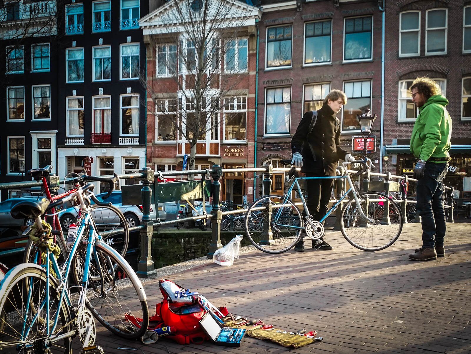Alex aan het werk aan de gracht, met een klant erbij